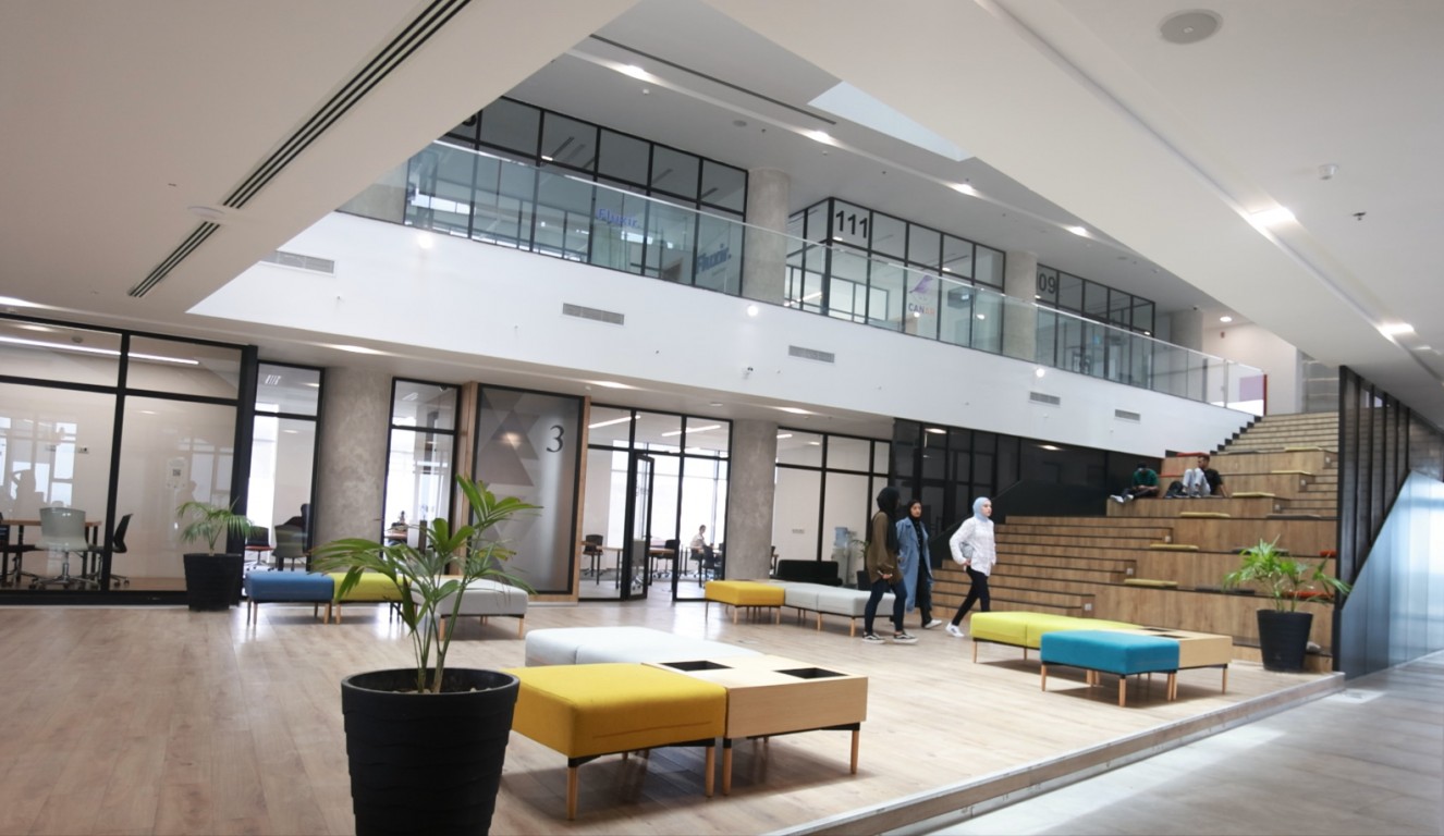 The ground-floor lounge, with soft seating and daylight from the full-height windows