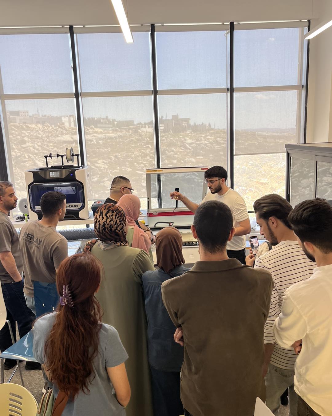 Participants gathered around equipment in the fabrication lab